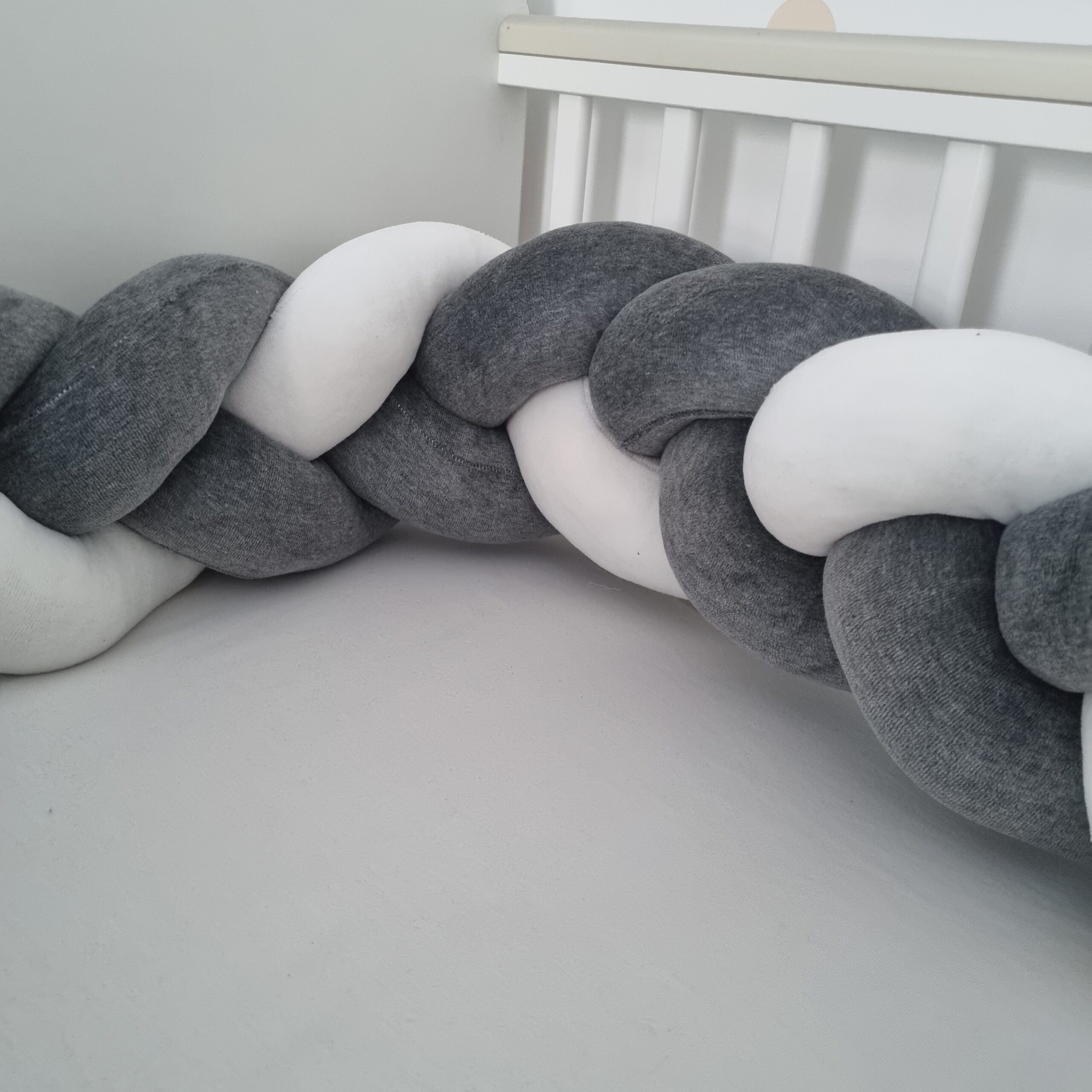 Fonott rácsvédő szürke fehér színben, babyplüss anyagból oldalról fényképezve