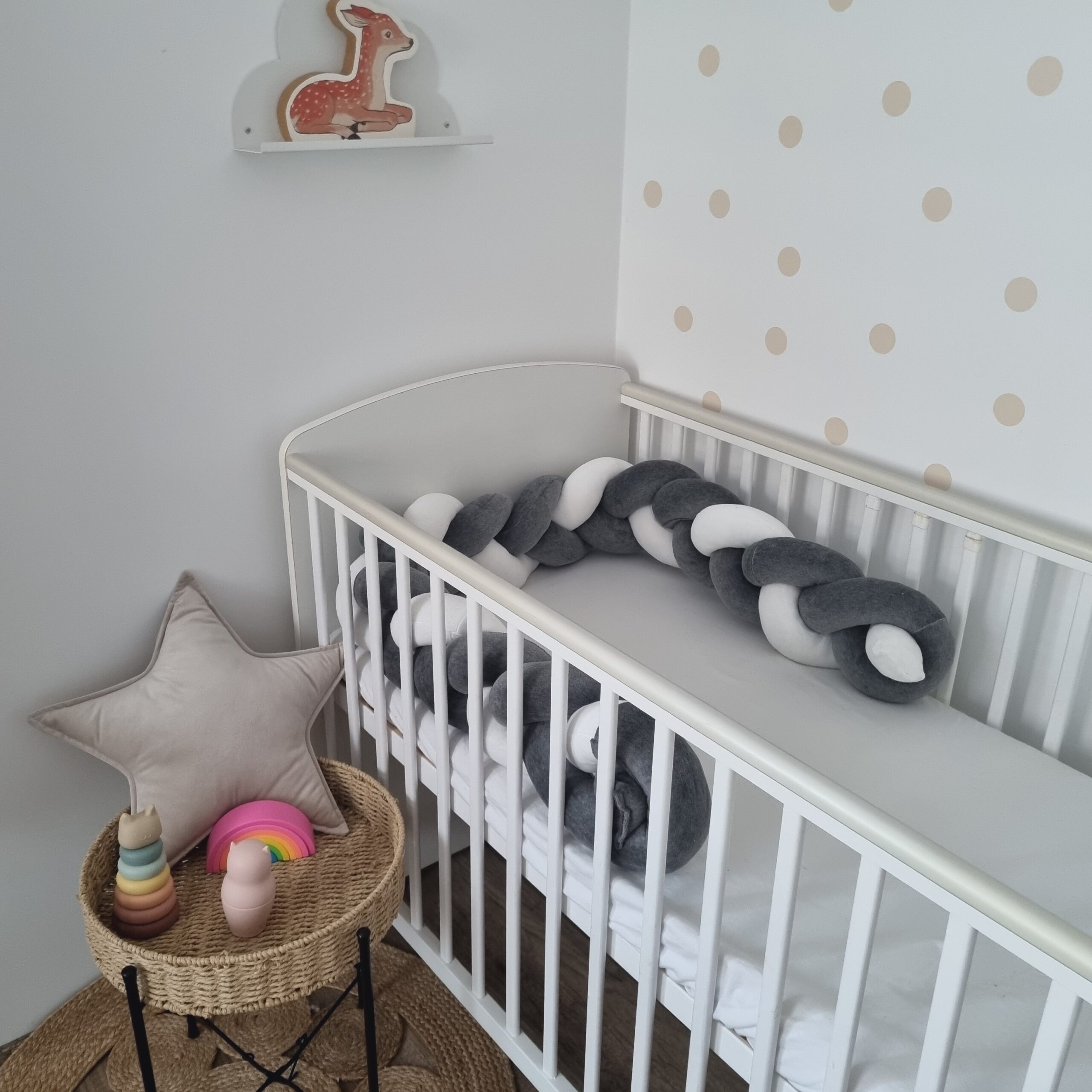 Fonott rácsvédő szürke fehér színben, babyplüss anyagból távolról fényképezve