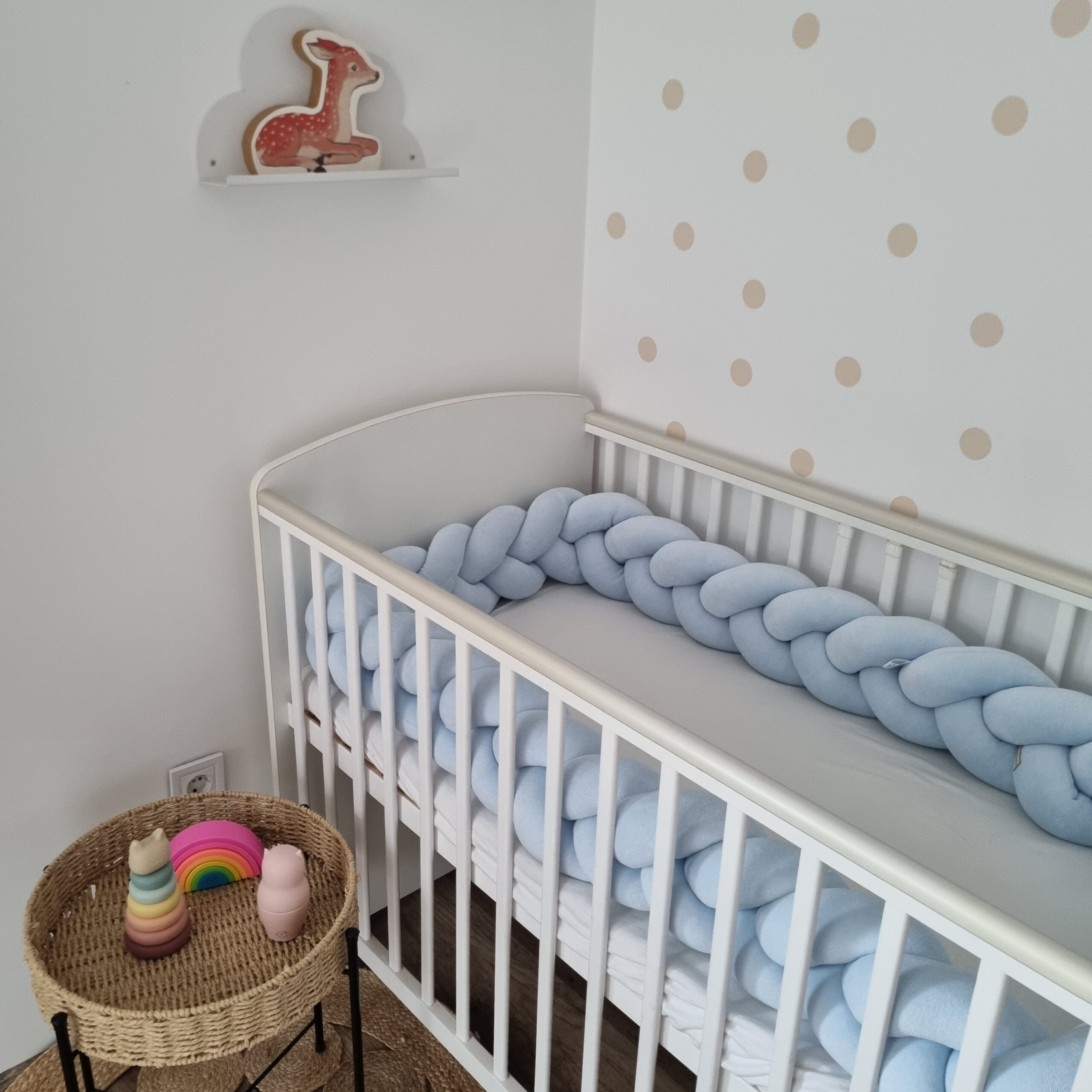 Fonott rácsvédő világoskék távolról, dekorációval fényképezve kiságyban