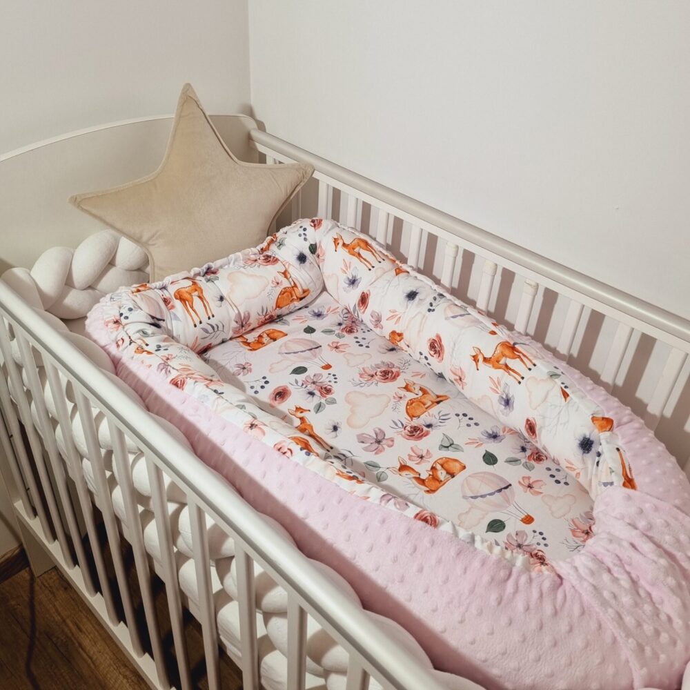 Őzike mintás babafészek oldalról babaágyban fényképezve