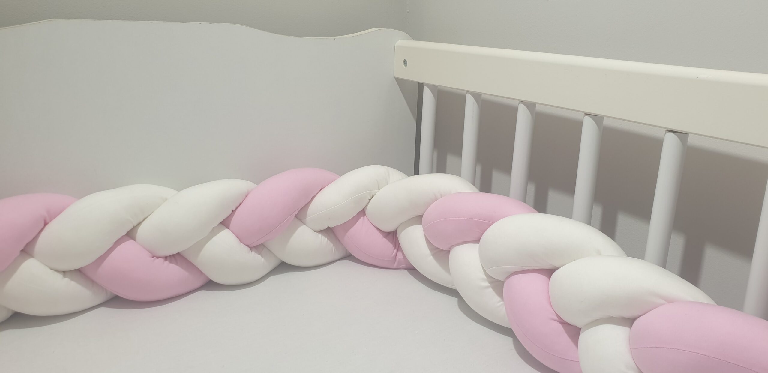 Fonott rácsvédő babyplüss, fehér és rózsaszín színben, oldalról fotózva