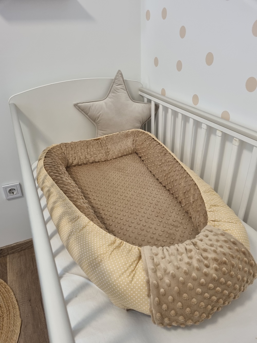 Drapp pöttyös babafészek dekorációval fényképezve