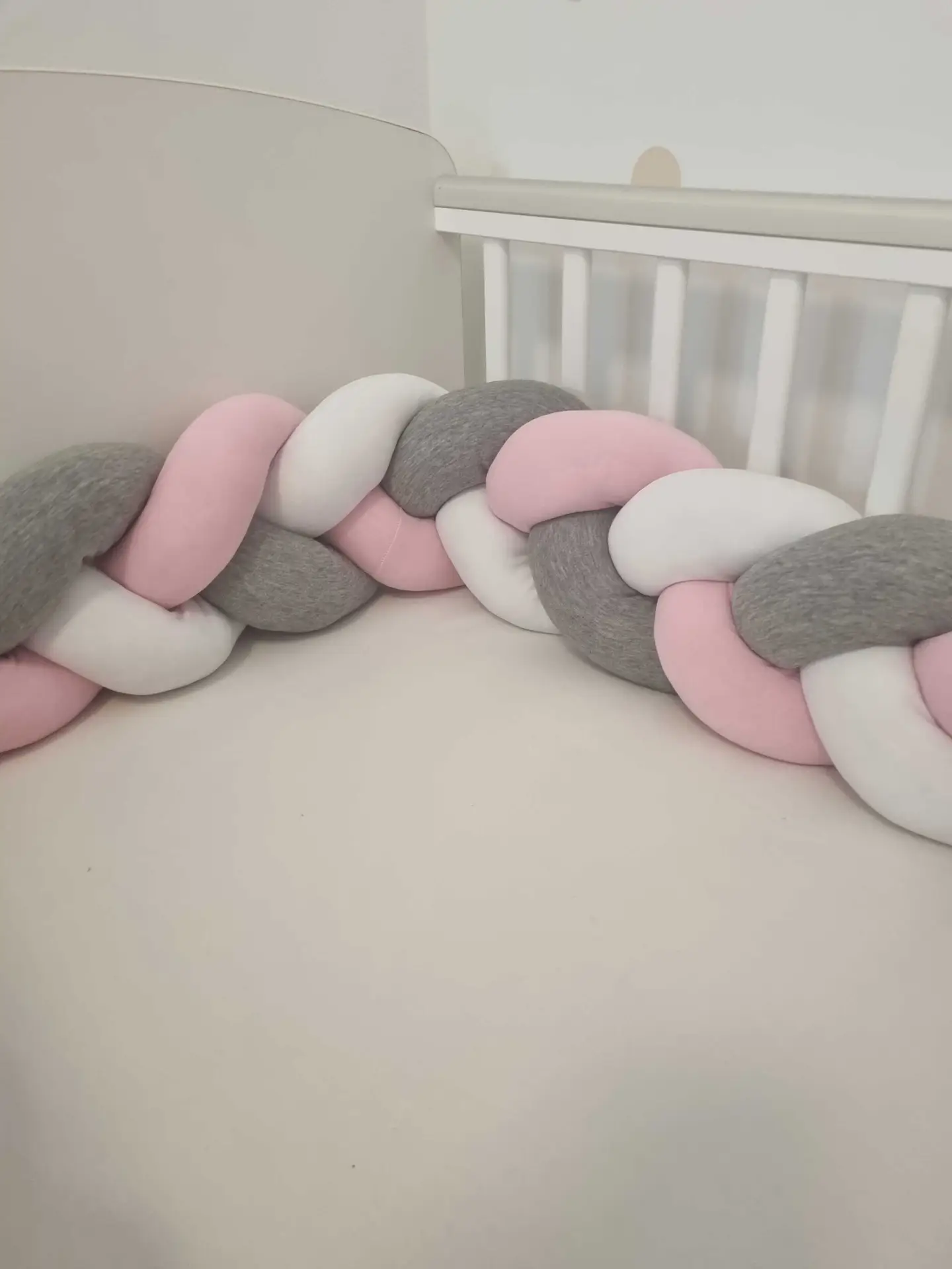 Fonott rácsvédő rózsaszín szürke fehér színben, babyplüss anyagból, oldalról fényképezve