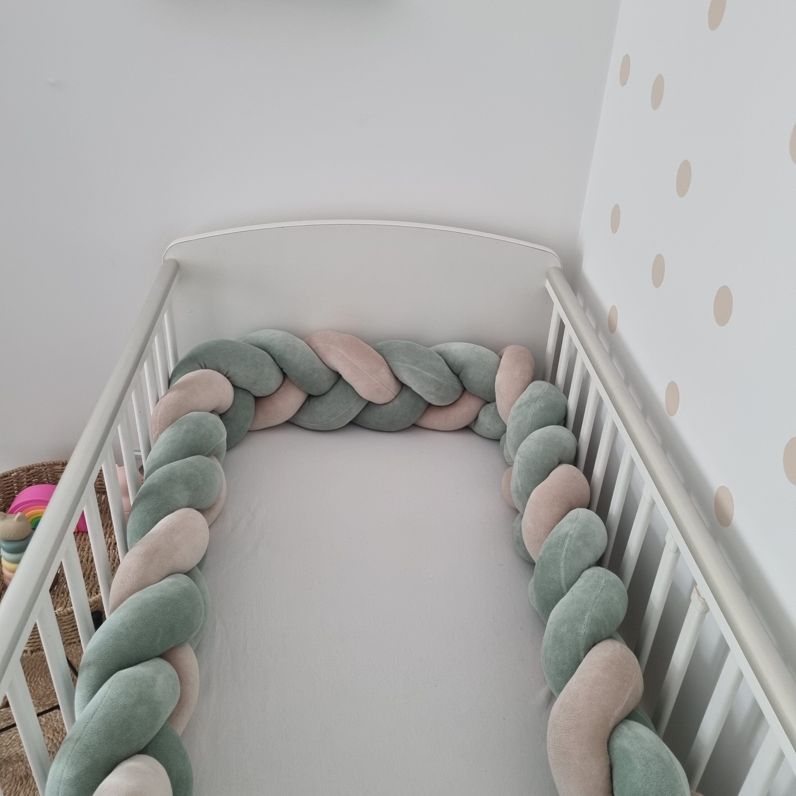 Fonott rácsvédő kiságyba, babyplüss anyagból, zsálya és bézs színekben, teljes kiságy távoli nézetben