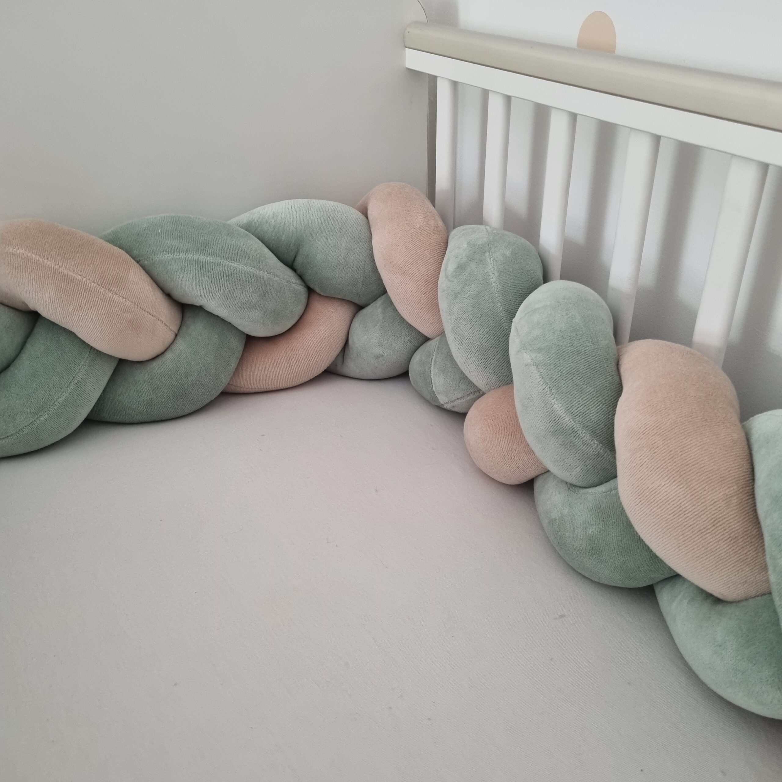 Fonott babyplüss rácsvédő zsálya és bézs színben, oldalnézetből